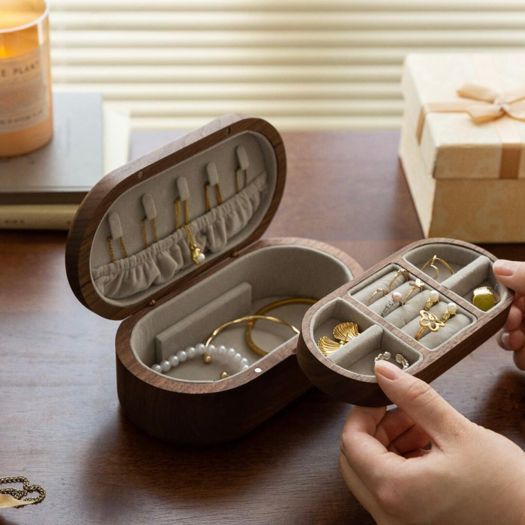 Walnut Wood Oval Jewelry Box Side View - Compact oval design with metal logo accent perfect for vanity table